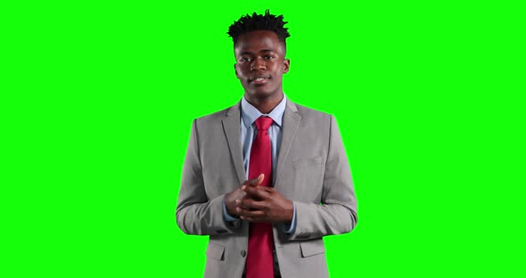 an African American man in suit talking in green background