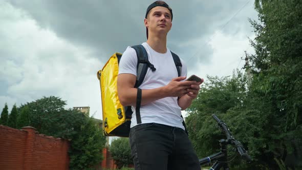 Lost Courier with Smartphone Standing on City Street Surfing Internet Looking Around alt