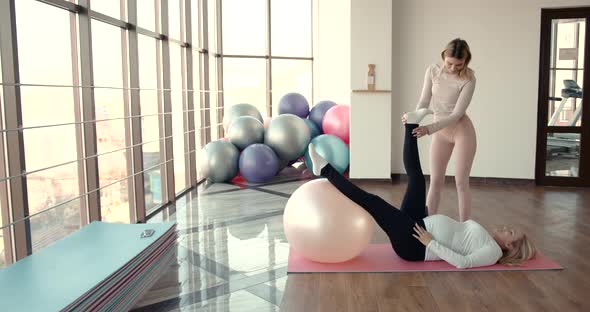 Pregnant Woman and Her Personal Trainer Doing Stretching Exercises alt