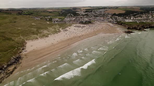 Perranporth Beach And Sea Full Of Summer Surfers and Swimmers Aerial View alt