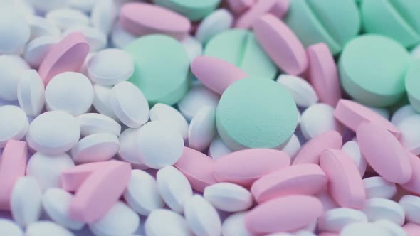 Round Green and Pink White Narcotic Drugs Lie Together on a Table and Rotate alt