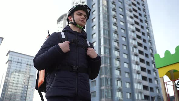 Delivery Man with Thermal Bag Walking Through City alt
