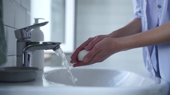 The man turned on the water tap and began to wash his hands thoroughly with soap