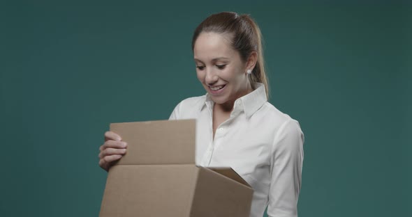 Woman receiving a bad surprise in a delivery box: she is scared and disgusted and she drops the box
