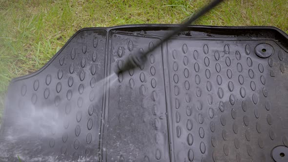 Close Up Cleaning of Car Mat with a Pressure Washer. alt