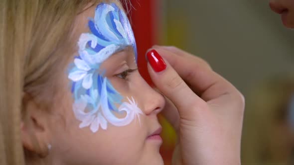 Artist's Hand Glueing Rhinestones on the Kid's Face. Close-up Motion alt