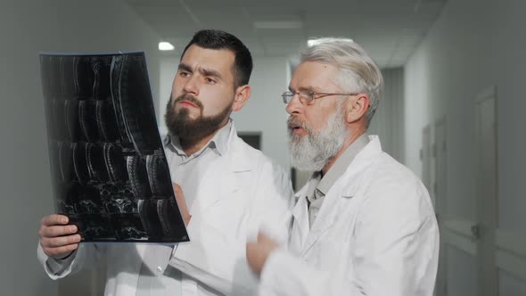 Two Male Doctors Discussing MRI Scan of Their Patient