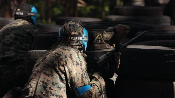 Portrait of Cheerful Adult People Playing Paintball on the Battlefield alt