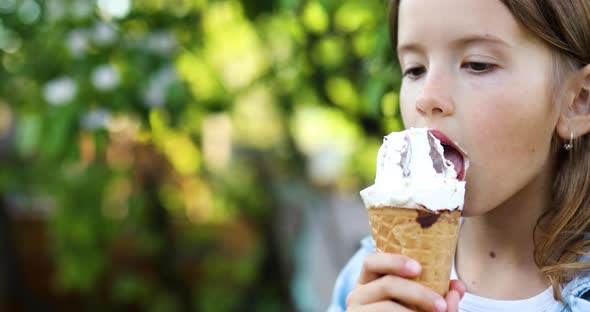 Cute Girl Eating Italian Ice Cream Cone Smiling While Resting in Park on Summer Day alt
