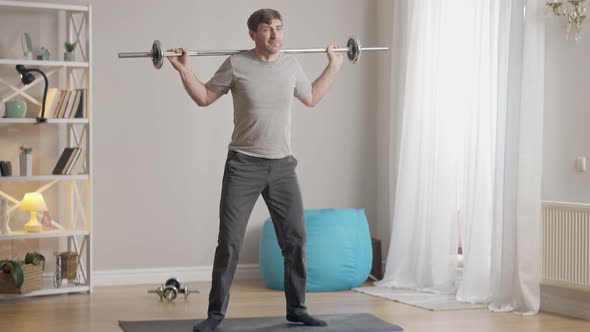 Live Camera Follows Confident Fit Sportsman Doing Squats Holding Barbell on Shoulders alt