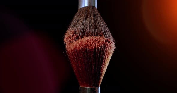 Two Make-up Brush with Powder on Black Background with Sunlight Colour Paint Concept Slow Motion alt