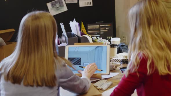 Female Designers Discussing Interior Plans on Digital Tablet