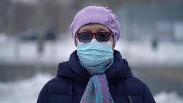 Portrait Elderly Woman in a Medical Face Mask Outdoors at Winter
