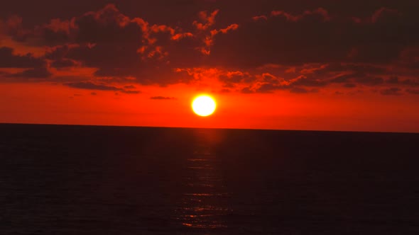 4K Sunrise. A fabulous image. The sun disappears through the red clouds.