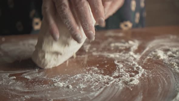 In the Early Morning Female Hands Knead the Dough on a Wooden Table