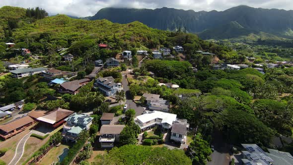 Drone Flying Over Beautiful Kaneohe neighborhood on Oahu in Hawaii, with Mountain Range in the Dista alt