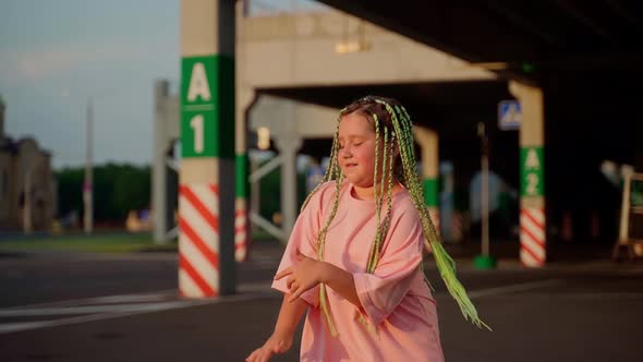 Girl dancing at parking outdoors. Cute professional child dancer expressing emotions using body