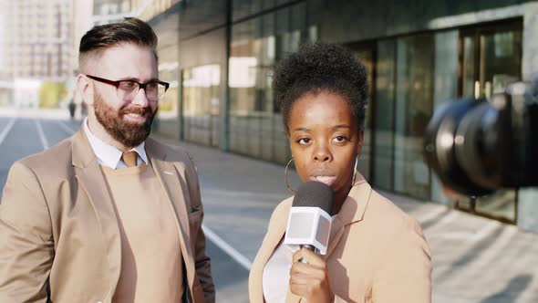 Businessman Giving Interview to Black Female Journalist Outdoors alt