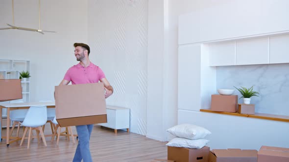 Bearded guy in t shirt looks at young woman blonde puts large cardboard box alt