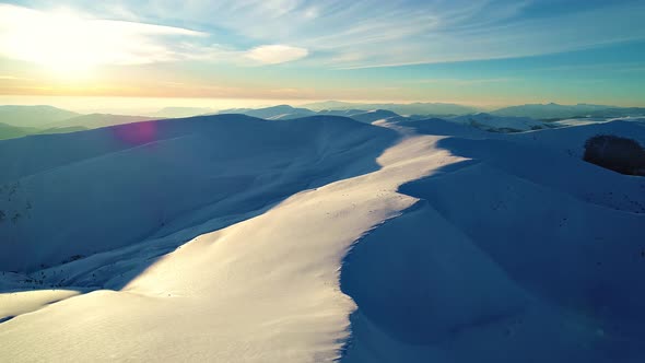 Flight Over the Snowy Mountains Illuminated By the Evening Sun alt