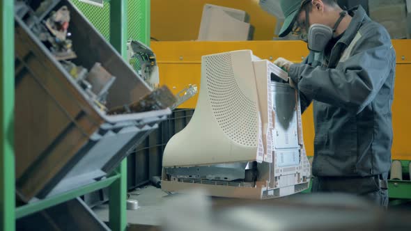 Trash, E-waste, Electronic Garbage Recycling Factory. A Person Takes Apart an Old Monitor at alt