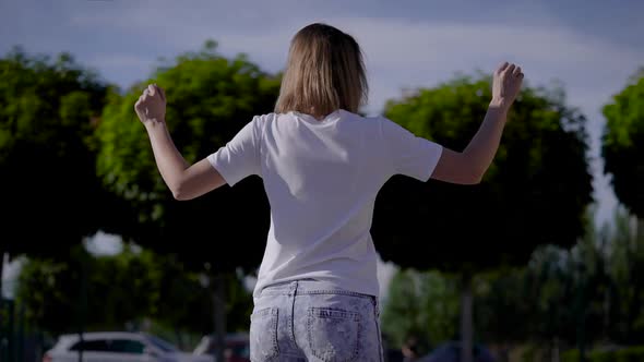 A Slender Young Girl Rides a Gyro Scooter Along a City Street. Modern Electric Transport. alt