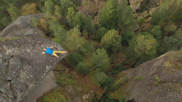 Top View A Young Man Lies on the Edge of a Cliff with His Eyes Closed alt