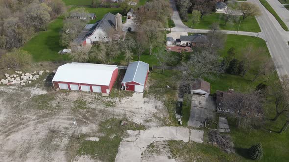 Top area view of large farm buildings with the city encroaching on the rural lifestyle.