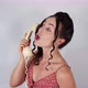 An attractive female model on a white background wearing a vintage dress talking fast on the phone - VideoHive Item for Sale