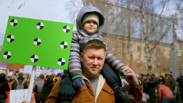 Family of Father and Son at Rally with Blank Chromakey Space Mockup Banner