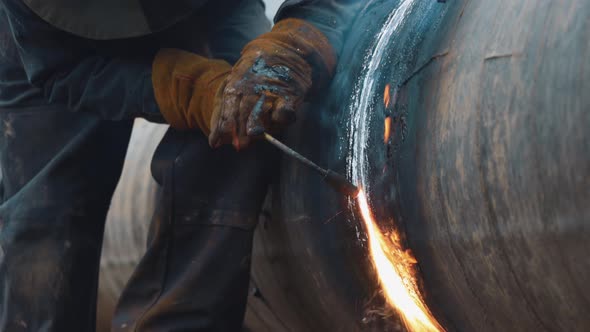 Welder at Work Cuts Metal Pipe