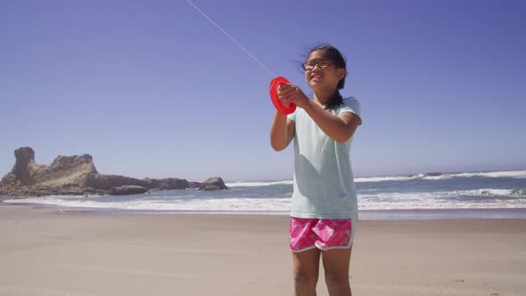 Young girl flying kite at beach