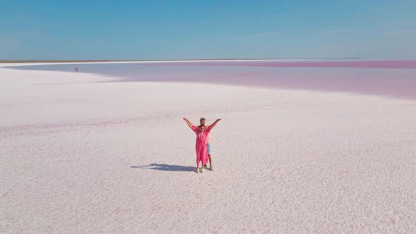 Circle Drone Flight and Aerial View of Happy Romantic Lovely Couple in Pink Wear Standing on White alt