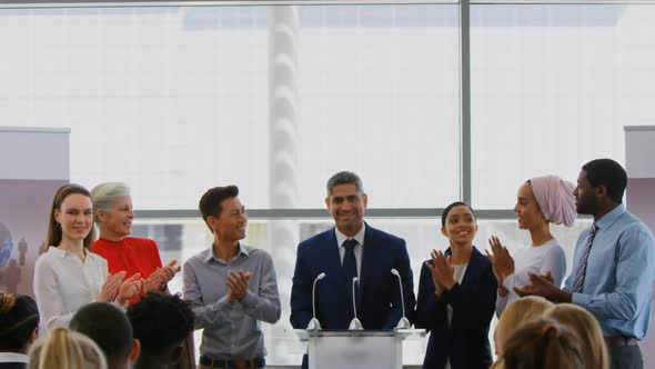 Businessman standing on the podium with his colleagues in the business seminar 4k alt