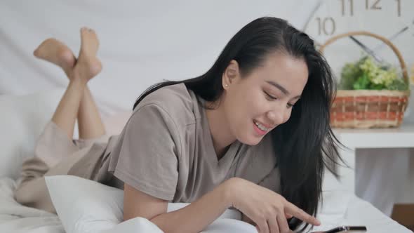 Close-Up Video Of Woman Lying In Bed Playing Social Media On Mobile Phone.