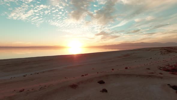 Cinematic sunset over Salton Lake in Riverside. Drone descending alt