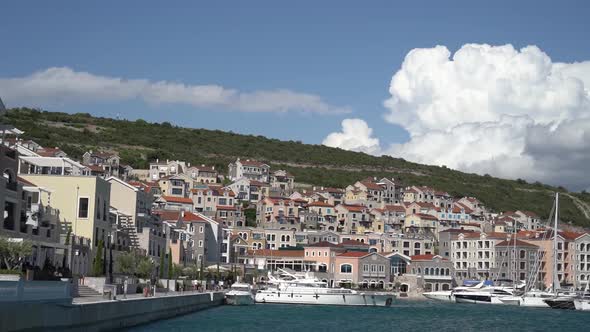 Buildings of the Lustica Bay Marina Against the Backdrop of Mountains alt