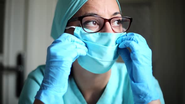 Woman doctor adjusting a surgical mask and glasses