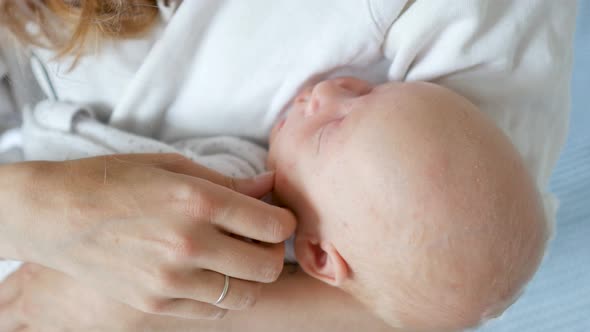 close-up baby sleeping in mother’s arms