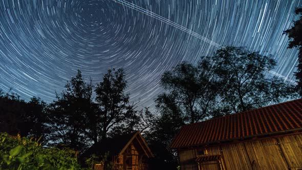 motion of stars as circular trails in northern direction to polaris over farm buildings alt