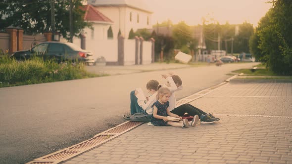 Schoolboy in White Shirt Throws Away Book Sitting By Friends alt