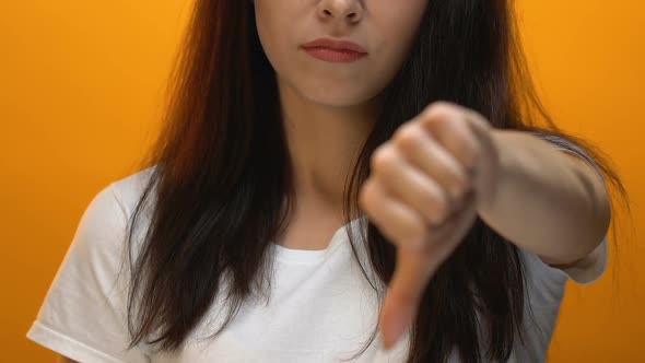Strict Disappointed Woman Showing Thumbs-Down Gesture, Disapproval, Close Up alt