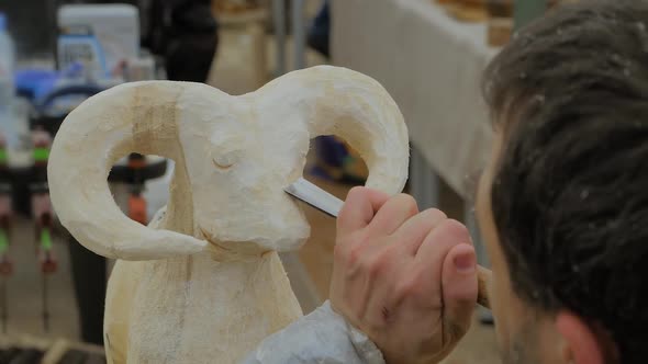Man Using Chisel for Carving Wooden Sculpture of Goat  Slow Motion Close Up