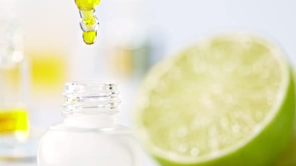 Super Slow Motion Shot of Oily Lime Essence Drop From Dropper Into Phial at 1000Fps alt