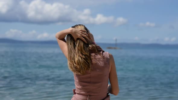View From Behind Of A Young Woman Enjoying Time By The Sea