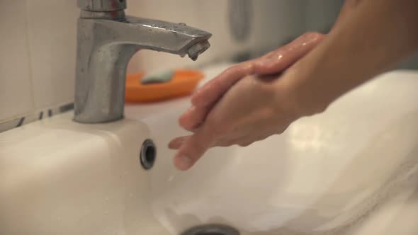 Hands of Man Wash Their Hands in a Sink with Foam to Wash the Skin