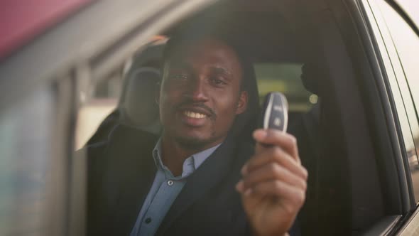 African American Businessman in Suit Sitting Inside His Luxury Electric Car with alt