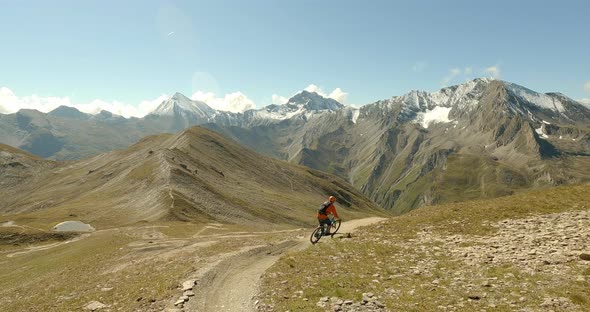 Cruising on a enduro mountainbike down a sigle trail with fun curves and amazing panorama landscape alt