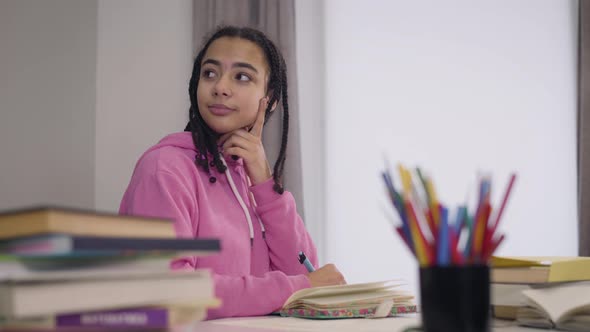 Young Caucasian Male Teacher Coming To African American Student and Looking Through Her Notes alt