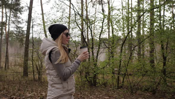 Beautiful Woman Walk in the Forest and Drink Coffee.  High Quality